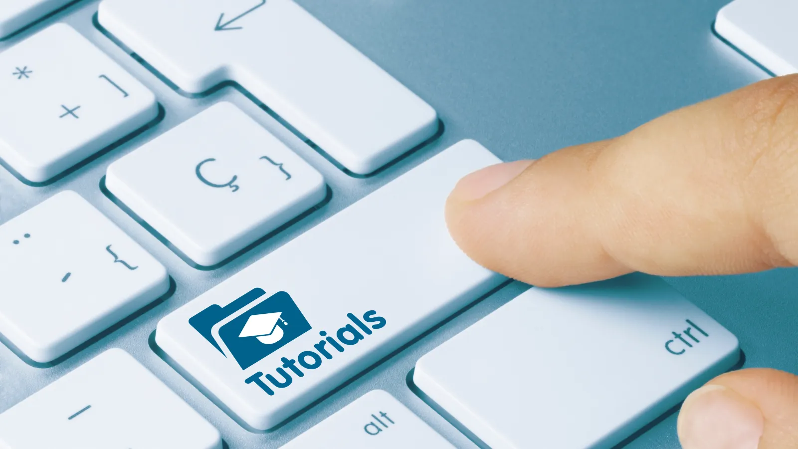 finger pressing key on laptop keyboard labeled "tutorials"
