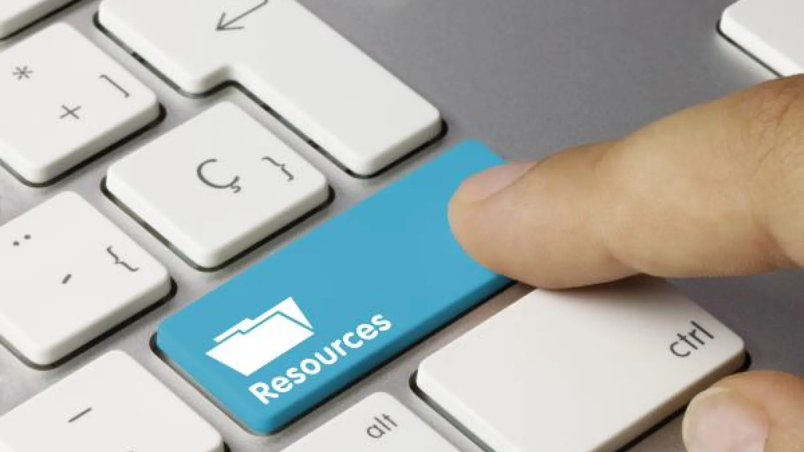 Human finger pressing on a Resources key on a keyboard