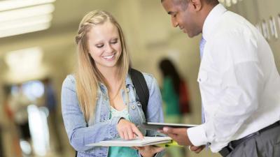 Female student and male professor looking at a document together