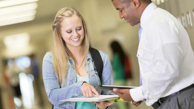 Female student and male professor looking at a document together