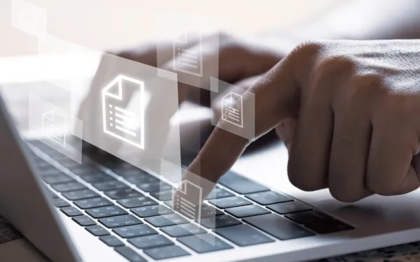Typing on a laptop with file icons